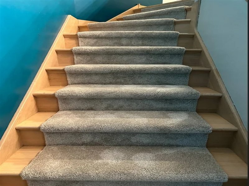 Stair carpet installation with grey plush carpet on wood stairs